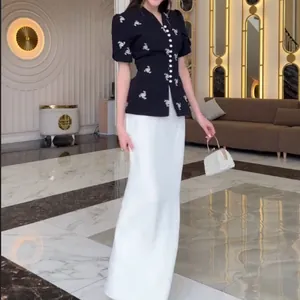 Full view of elegant floral puff sleeve top with long white column skirt two-piece set
