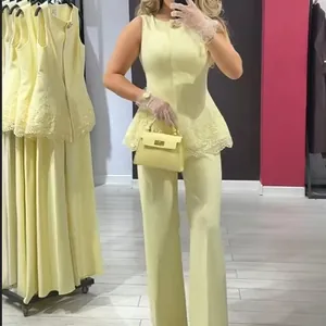 Elegant pale yellow sleeveless lace trimmed peplum top and matching wide leg pants set.