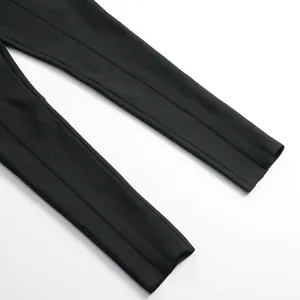 Detailed close-up view of black bandage jumpsuit pencil trouser cuffs with center seam stitching