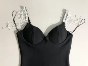 Close-up of black bandage dress featuring heavy craftsmanship rhinestone tassel shoulder straps