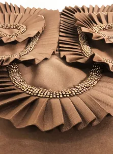 Close-up of premium handmade bronze beading and pleated ruffles on a bandage dress