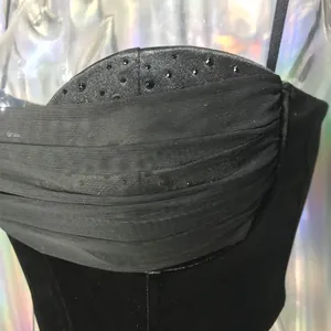 Nahaufnahme der Mesh- und Strassverzierungen auf dem eleganten schwarzen Bustier-Top