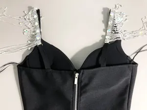 Detailed macro view of black bandage dress featuring heavy crystal tassel fringe straps