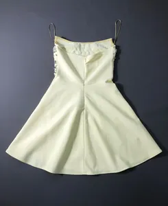 Detailed back view of a yellow heavy craft rhinestone evening dress with a flared skirt