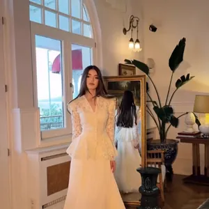 Elegant white lace two-piece set with peplum top and long skirt in a chic room