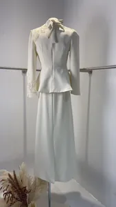 Vue arrière d'un ensemble jupe blanc élégant avec broderie papillon et veste chic