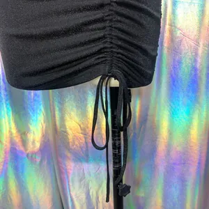 Close-up detail of the ruched side and drawstring on black shimmering party dress