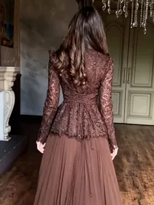 Vue arrière détaillée d'un élégant haut en dentelle marron avec jupe longue plissée