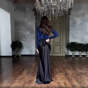 Elegant blue lace and black satin long-sleeve dress shown from the back in a luxury room.