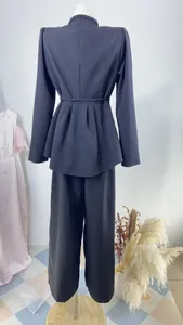 Vue arrière d'un élégant ensemble haut à basques bleu marine et pantalon large pour femme