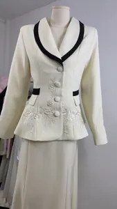 Detailed view of white floral embroidery on cream French style blazer and skirt set