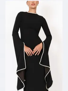 Elegant black long-sleeved evening dress featuring white pearl trim on neckline and cuffs