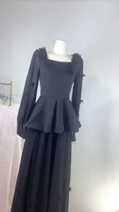 Vue frontale d'une robe française noire montrant le design de la taille peplum.