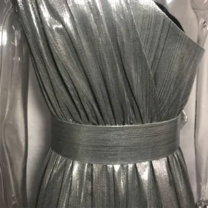 Primer plano del detalle de la textura plisada plateada metalizada de un vestido sexy