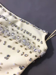 Close-up of sparkling rhinestone and pearl embellishments on a bandage evening dress