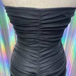 Close-up of black sparkly ruched fabric detail on a slim-fit bodycon party dress