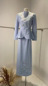 Détail du costume à basque bleu clair avec broderie florale complexe sur mannequin