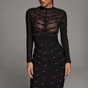 Elegant black long-sleeved bandage dress featuring sheer mesh panels and gold studs