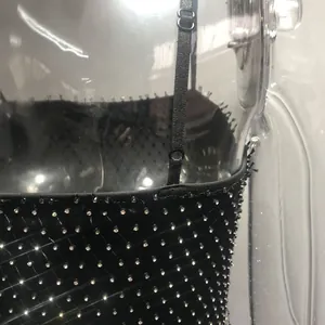 Close-up detail of sexy black dress with sparkling diamond grid and adjustable straps