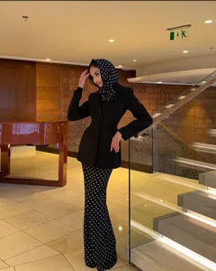 Elegant black blazer suit with polka dot skirt and matching headscarf in luxury interior