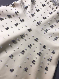 Close-up of luxury evening dress with white pearls and silver rhinestone embellishments