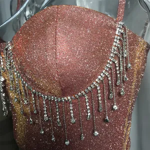 Detailansicht eines schimmernden roségoldenen Oberteils mit glänzenden Strass-Fransen.