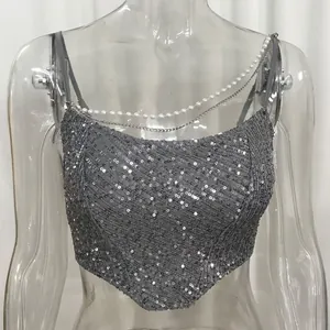 Detailed shot of silver sequined corset top with pearl and metal chain straps.