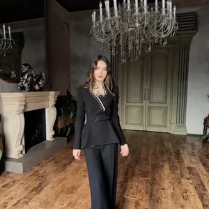 Full body view of a black blazer suit with rhinestone tassels in a luxury setting