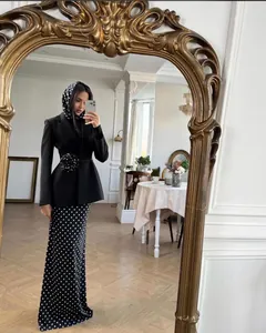 Elegant black blazer with 3D floral detail paired with a long polka dot skirt