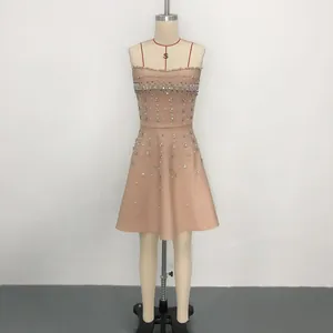 Detailed view of a nude bandage dress featuring heavy rhinestone and crystal embellishments.
