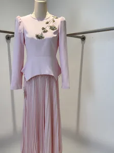 Elegant pink long-sleeved pleated maxi dress with sophisticated floral beadwork detail