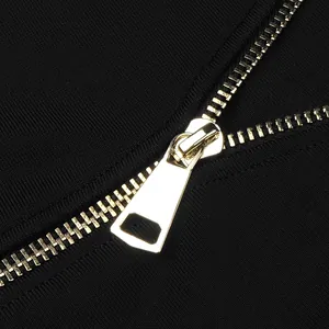 Macro shot of a high-quality gold metal zipper detail on a black bandage evening gown.