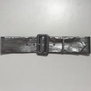 Primer plano de un cinturón plateado con textura metálica y hebilla rectangular.