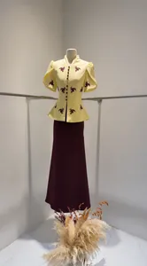 Detail view of yellow puff-sleeve embroidered top and wine-red maxi skirt set suit