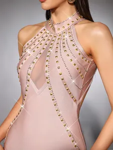 Primo piano di un elegante abito a fascia rosa con borchie dorate e dettagli in rete velata