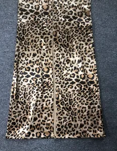Close-up macro view of the leopard print fabric and rear slit detail on a long dress