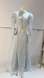 Dettaglio di un set in pizzo celeste con maniche a sbuffo e top peplum su manichino.