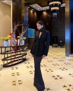 Elegant black blazer and polka dot maxi skirt set shown on a model in a luxury lobby