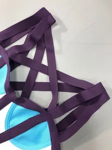 Gros plan des bretelles croisées violettes sur une robe bandage bleue et blanche