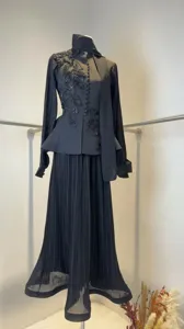 Detail view of elegant black pleated skirt set with floral embroidery and mesh sleeves