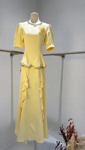 Elegant yellow evening gown featuring beaded neckline and ruffled fishtail design