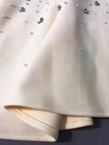 Macro detail of high-quality bandage fabric with sparkling rhinestones and pearls
