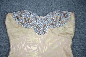 Detailed view of luxury crystal rhinestones on a gold foil strapless bandage dress