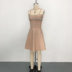 Detailed view of champagne bandage dress with intricate rhinestone and pearl embroidery