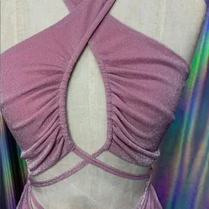Close-up of pink glittery halter dress with pleated details and criss-cross straps