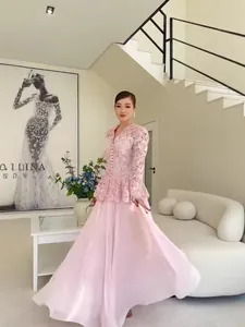Elegant pink lace two-piece set featuring a peplum top and a long flowing skirt for women