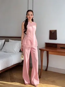 Elegant pink sleeveless lace-trimmed peplum top and wide-leg trousers two-piece set for women