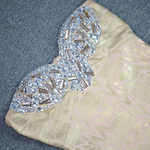 Detailed view of sparkling rhinestones on a luxury gold-stamping bandage dress bodice.
