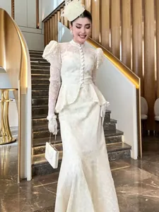 Elegante completo due pezzi in pizzo bianco con collo alto, maniche a sbuffo e peplo