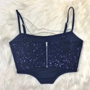 Close-up detail showing the back of a navy blue sequin crop top with chain and zipper